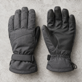 Pair of charcoal-gray Trailhead insulated winter gloves with articulated fingers, textured palms, and adjustable cuffs on a light stone background.